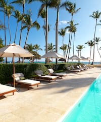 a pool with lounge chairs and umbrellas