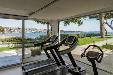 a gym with treadmills and a view of water and a city