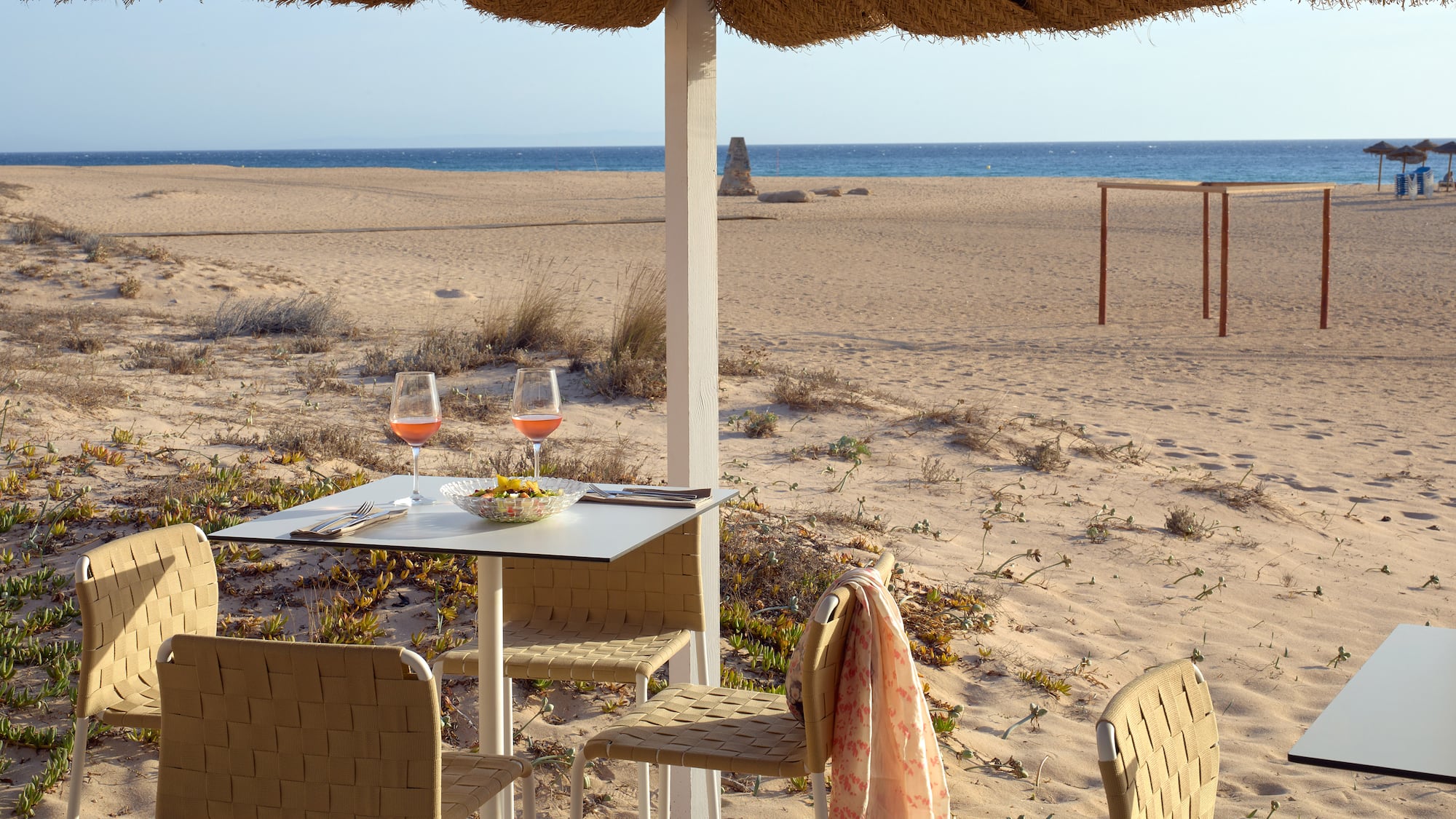 a table and chairs on a beach