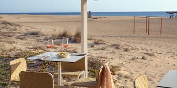 a table and chairs on a beach