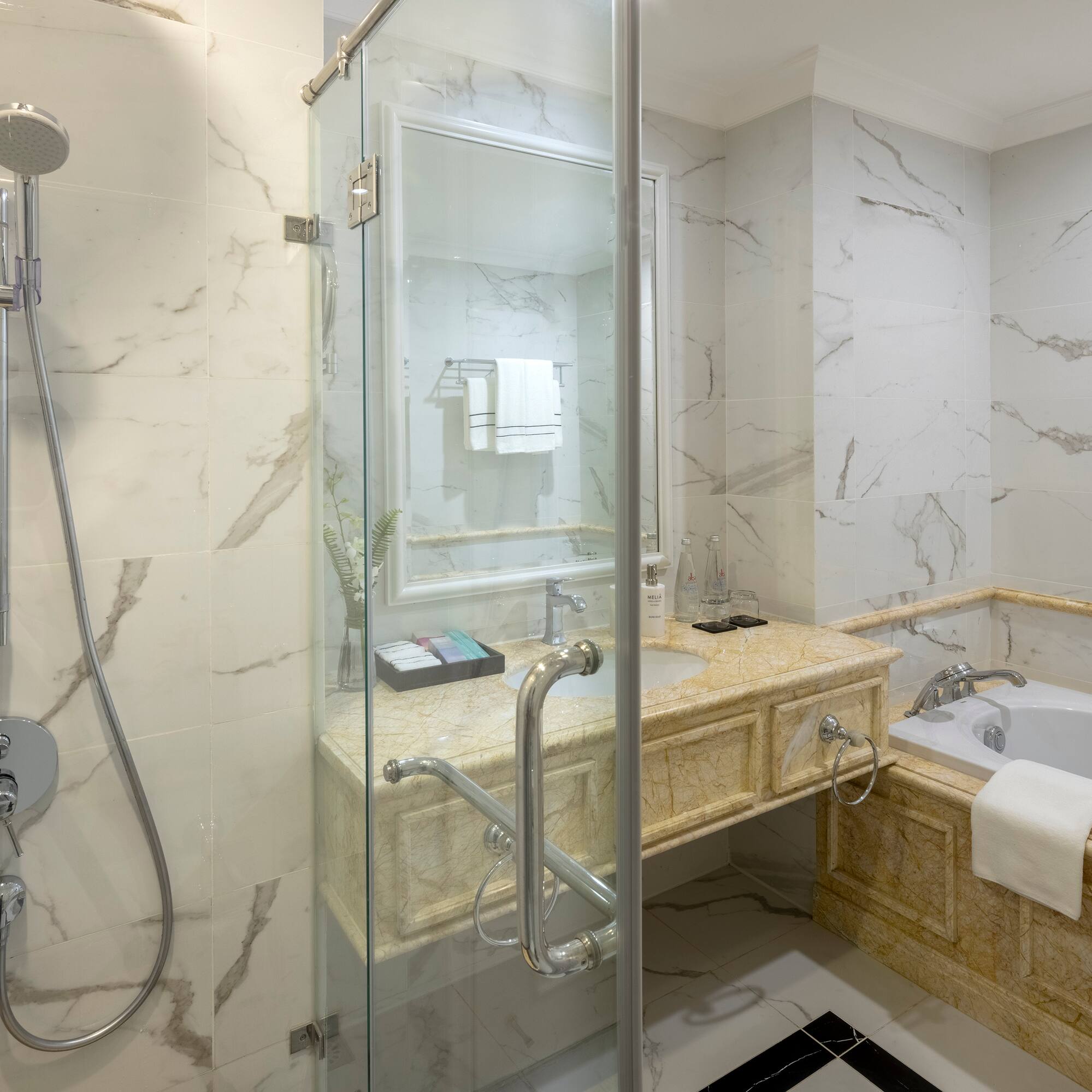 a bathroom with a glass shower door and tub