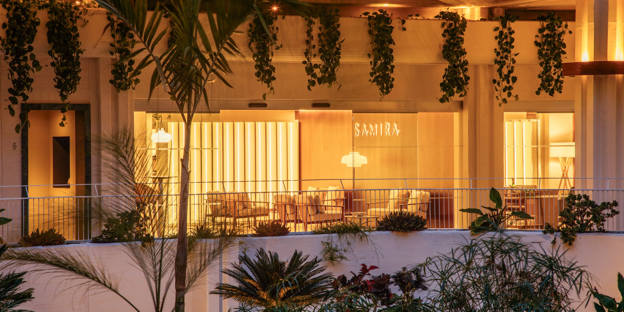 a building with a balcony and plants