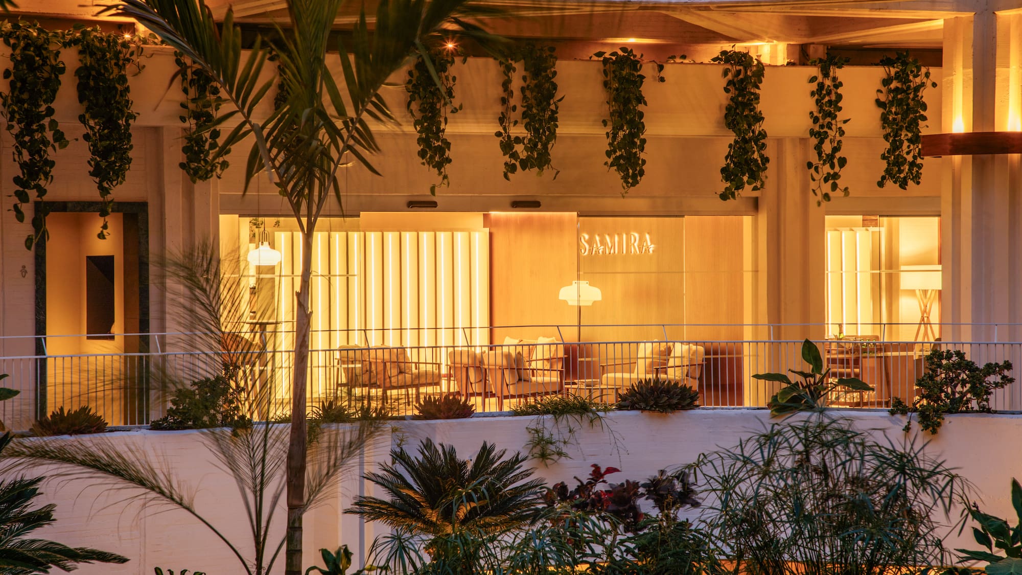 a building with a balcony and plants