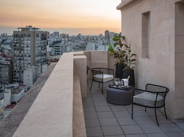 a balcony with chairs and a table and a city view