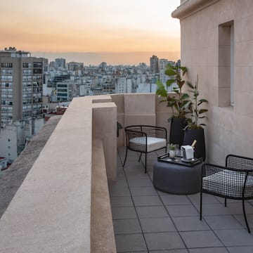 a balcony with chairs and a table and a city view