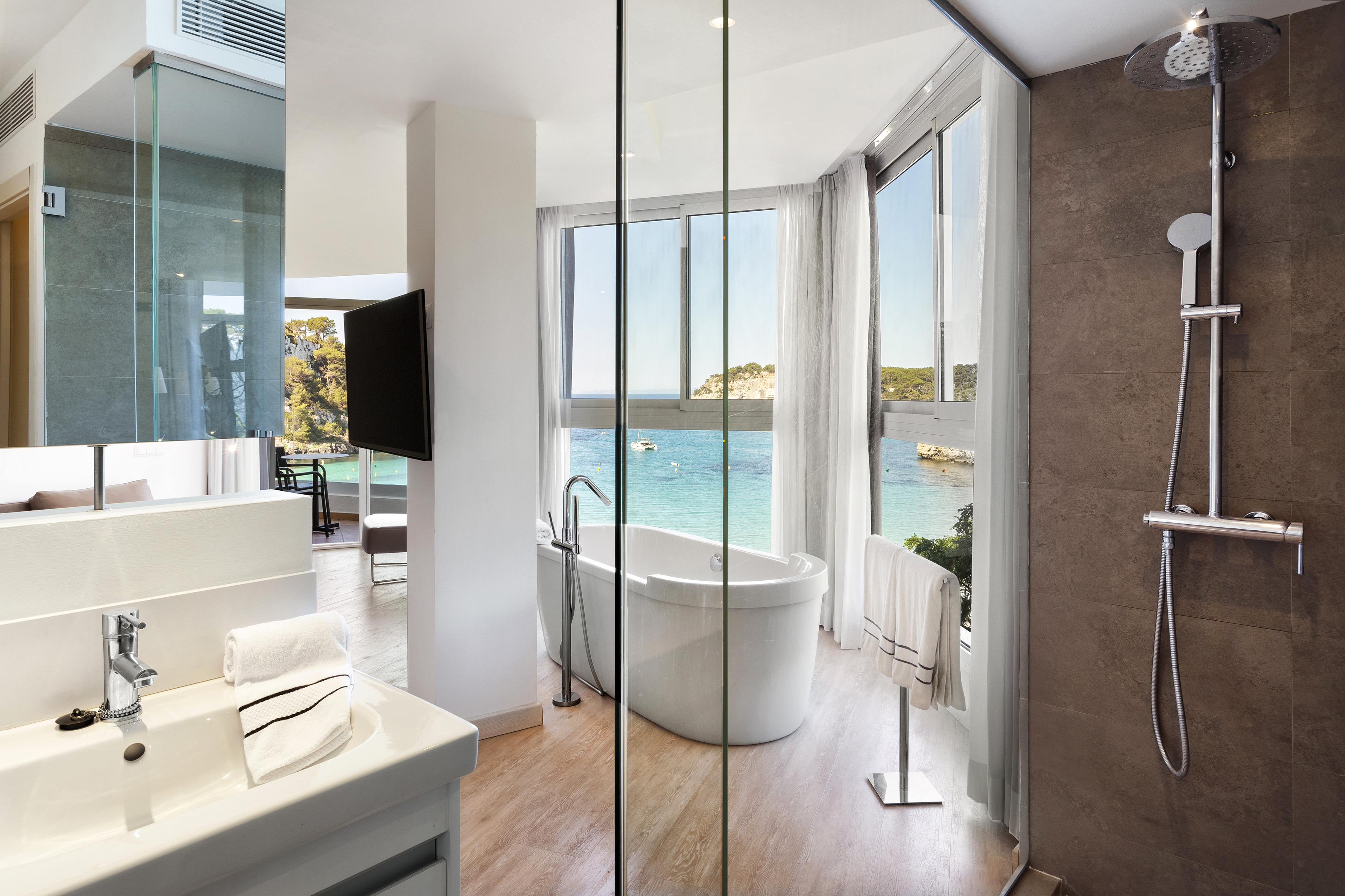 Luxury modern bathroom with bay view, freestanding tub, and shower.