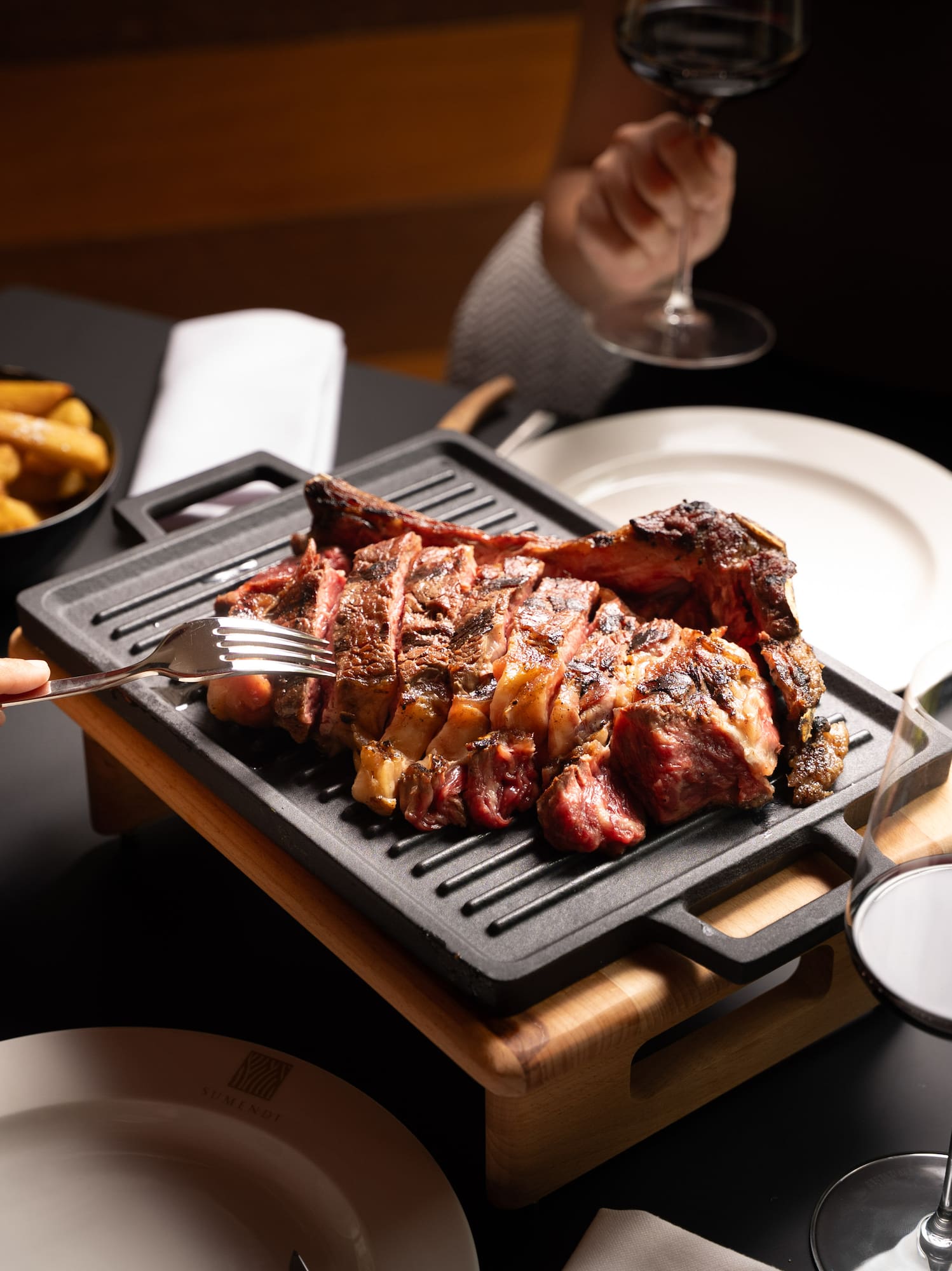 a group of people eating meat on a grill