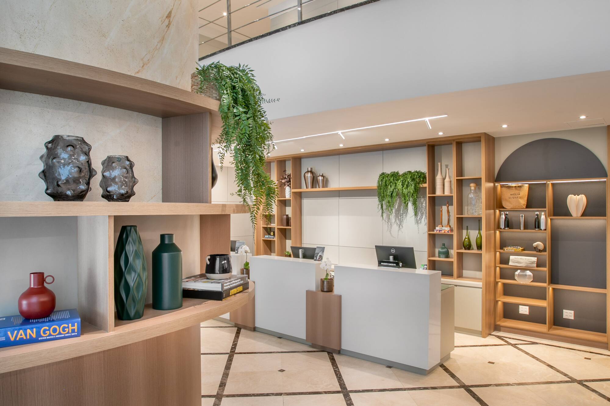 Modern hotel lobby with sleek reception desk, wooden shelves, and marble accents.