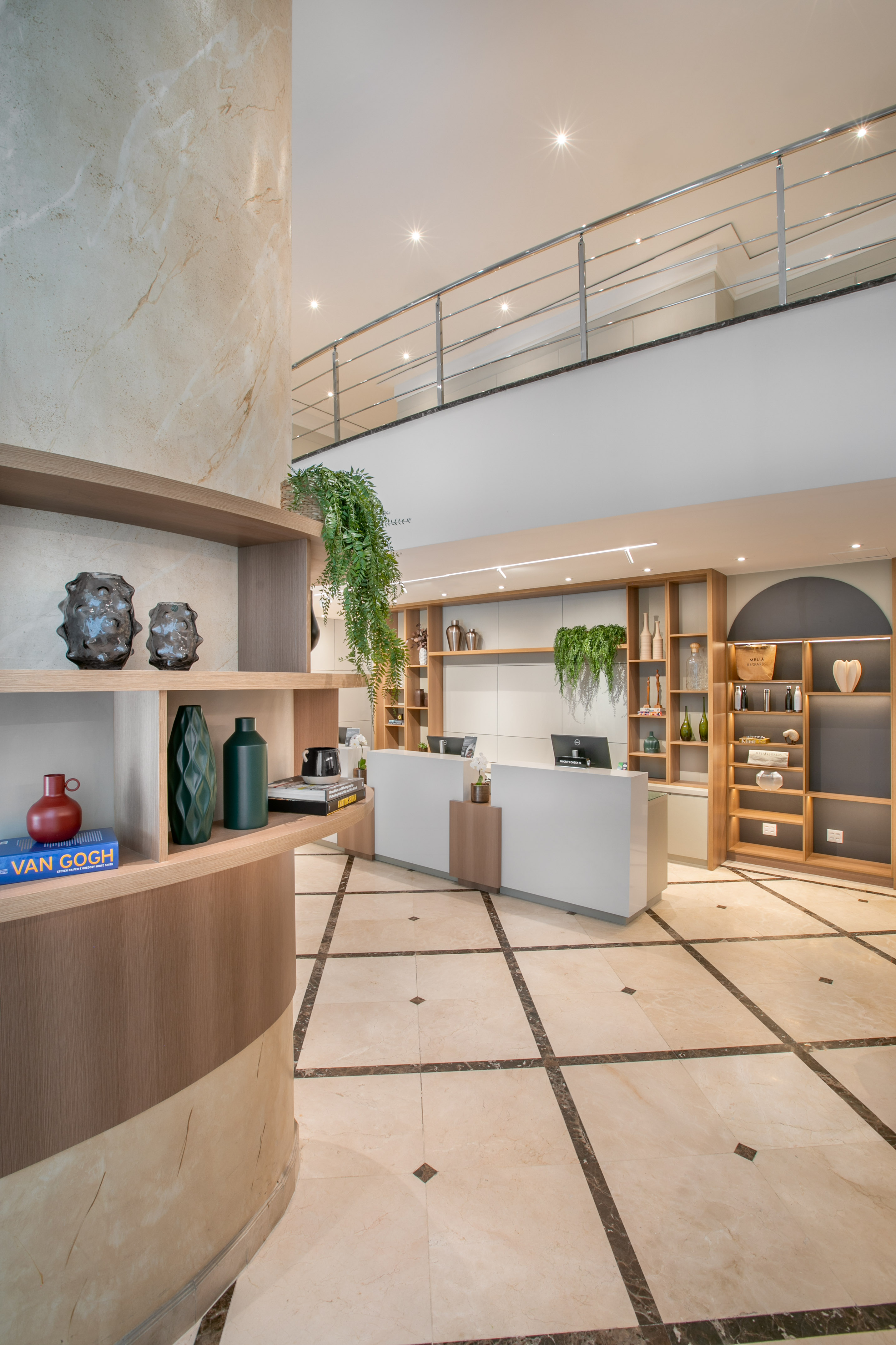 Modern hotel lobby with sleek reception desk, wooden shelves, and marble accents.