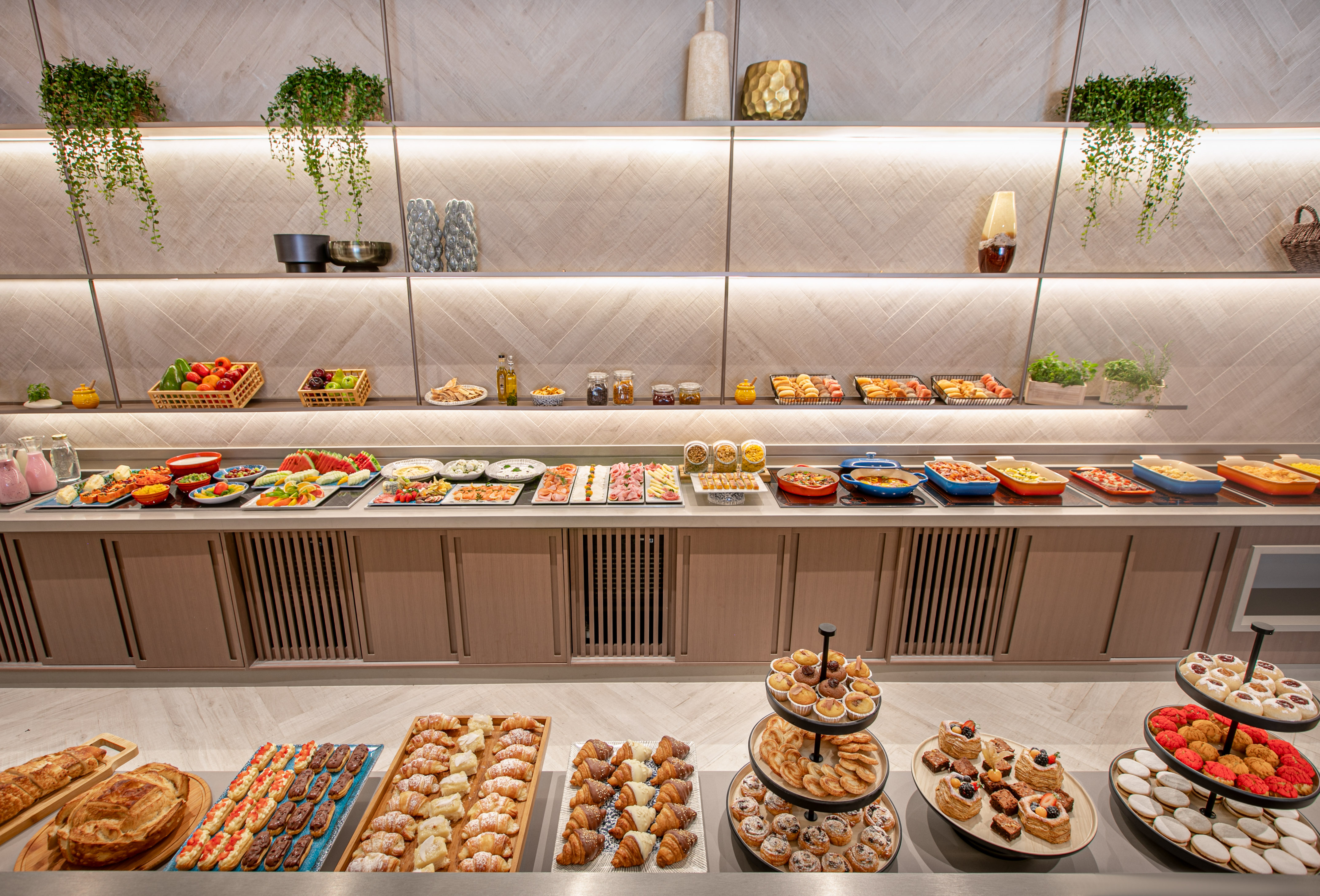 Hotel breakfast buffet: hot dishes, fresh fruit, pastries, croissants, and desserts.