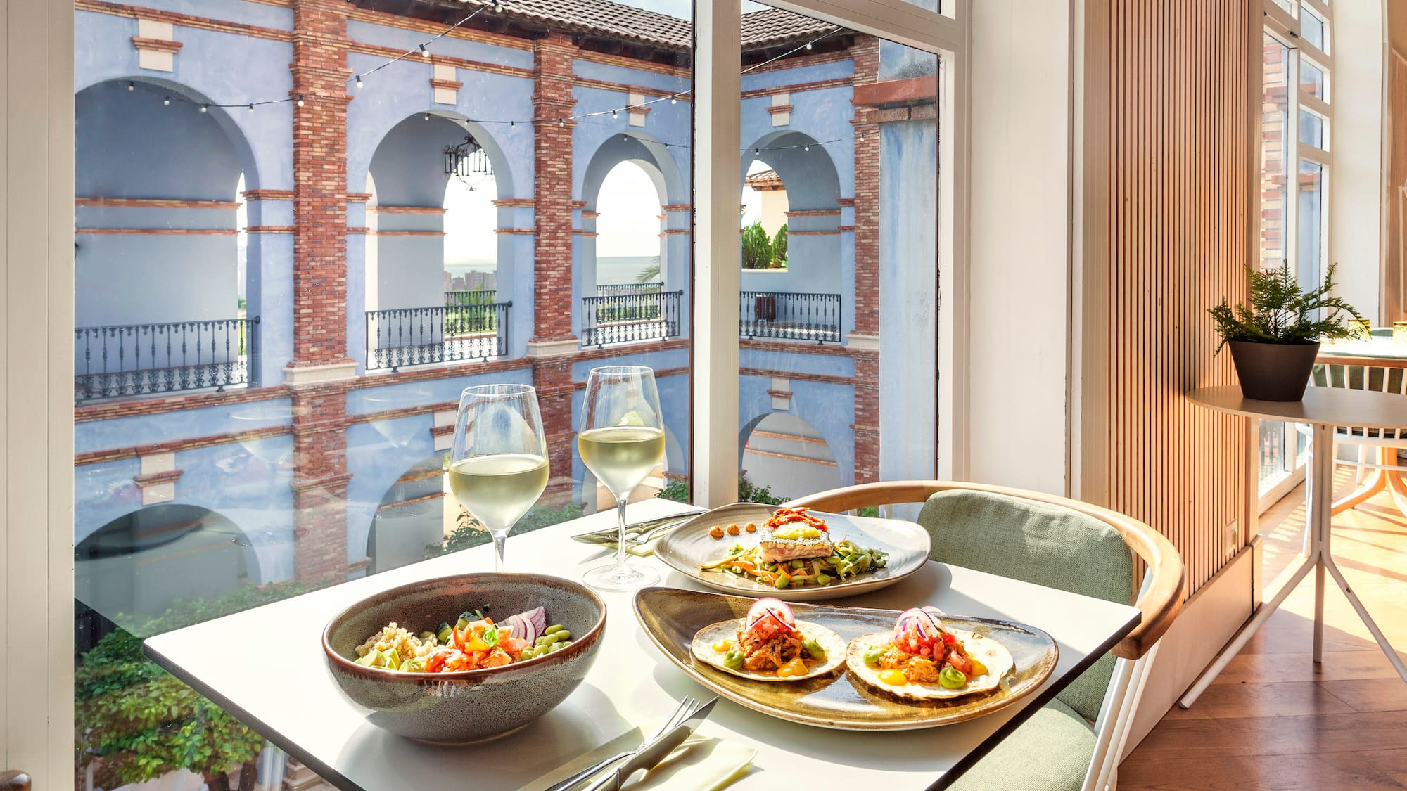 a table with plates of food and wine glasses on it