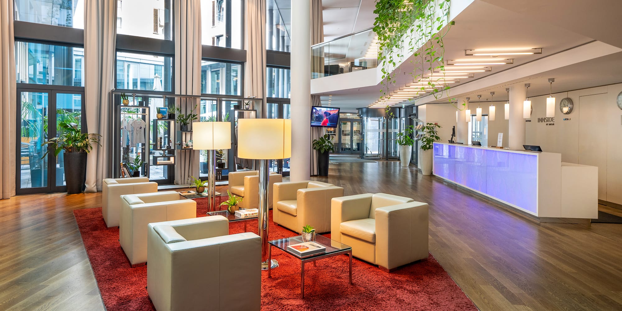 a lobby with white chairs and a red rug