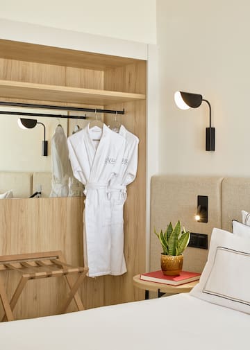 a room with white bathrobes and a plant