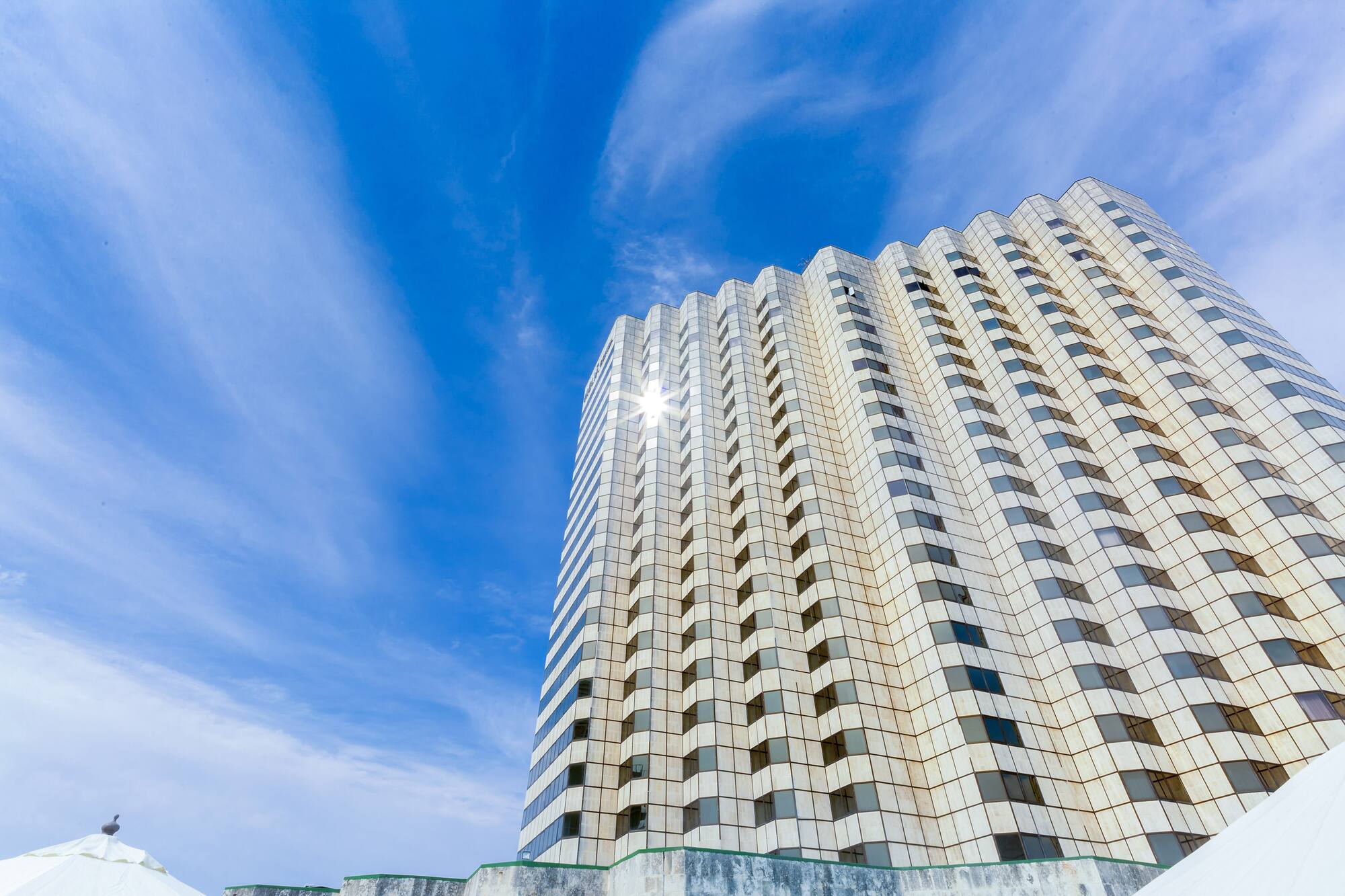 a tall building with a blue sky and clouds