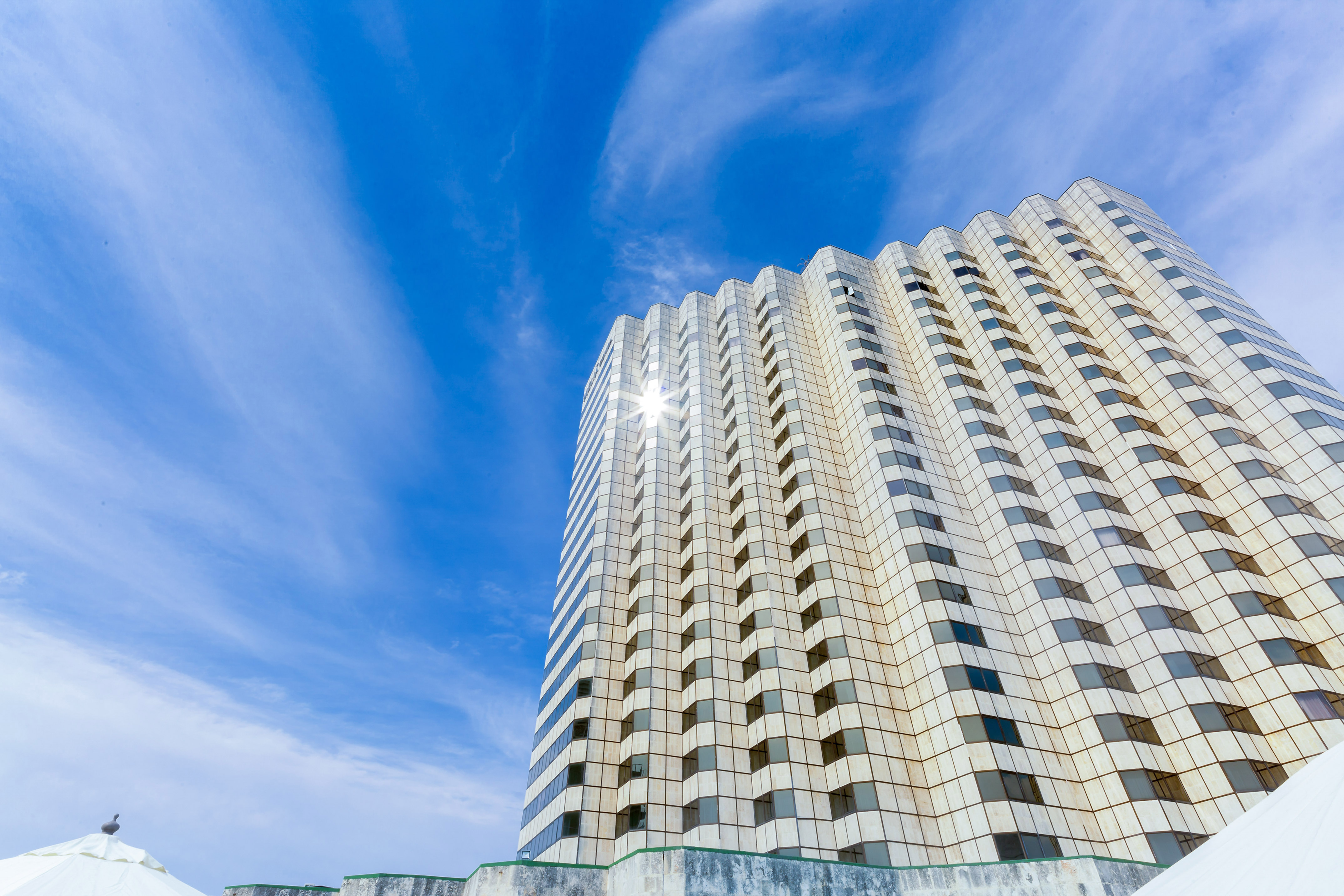 a tall building with a blue sky and clouds