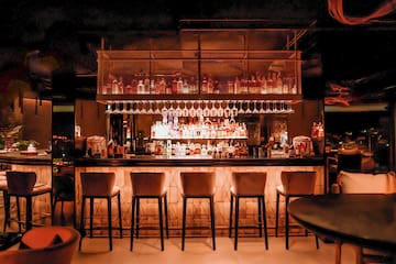 a bar with many glasses and a shelf above it