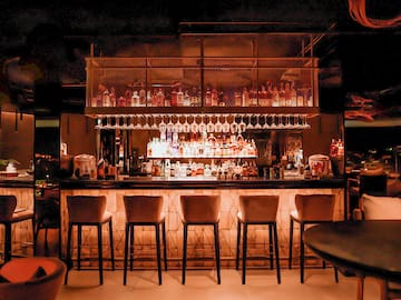 a bar with many glasses and a shelf above it