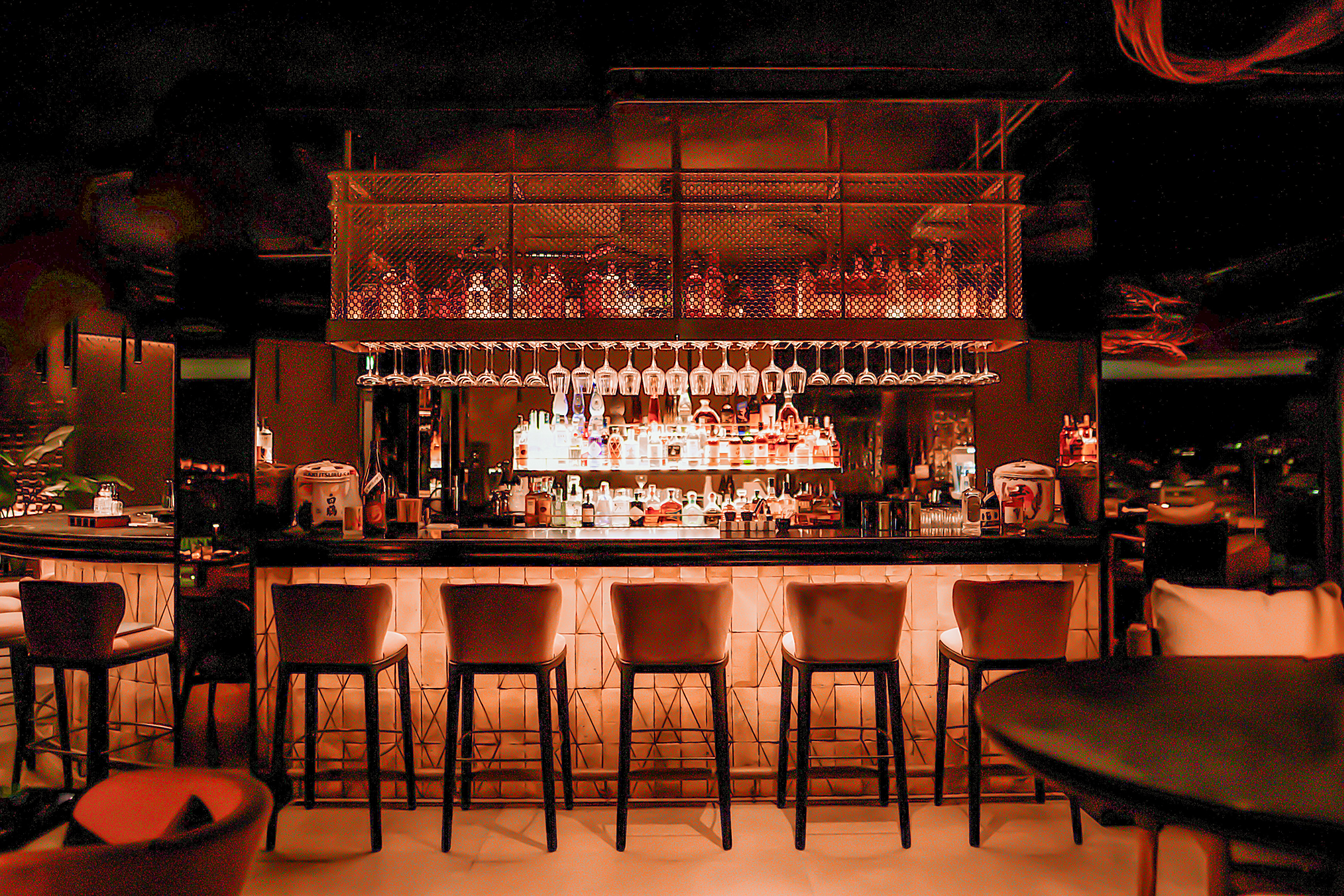 a bar with many glasses and a shelf above it
