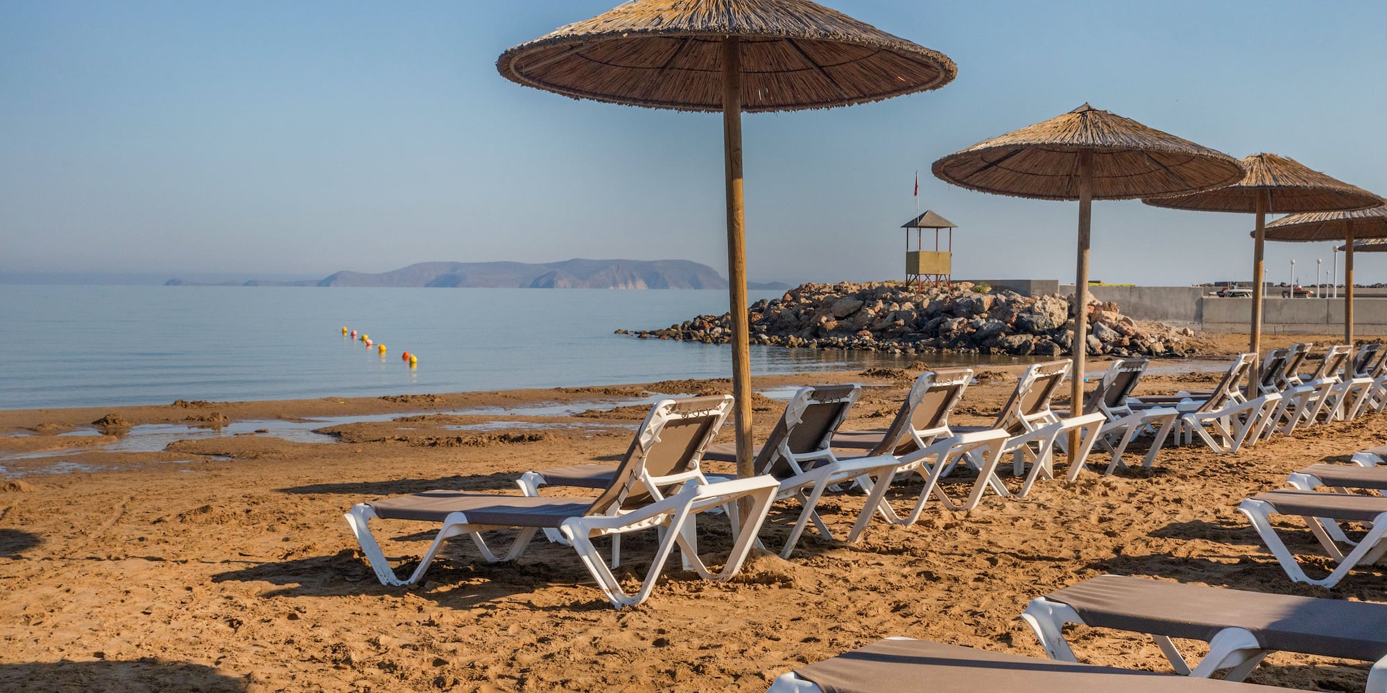 a beach with chairs and umbrellas