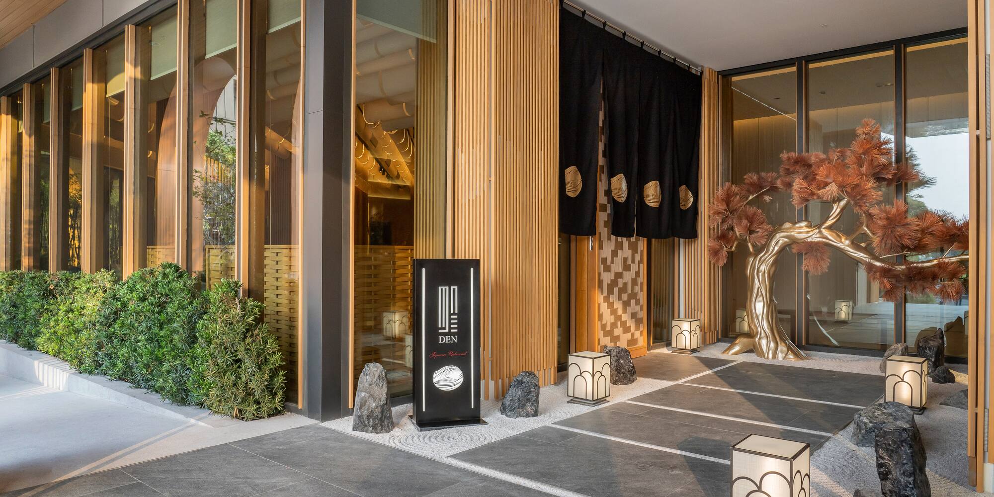 a building with a tree and lanterns