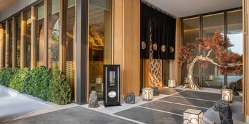 a building with a tree and lanterns
