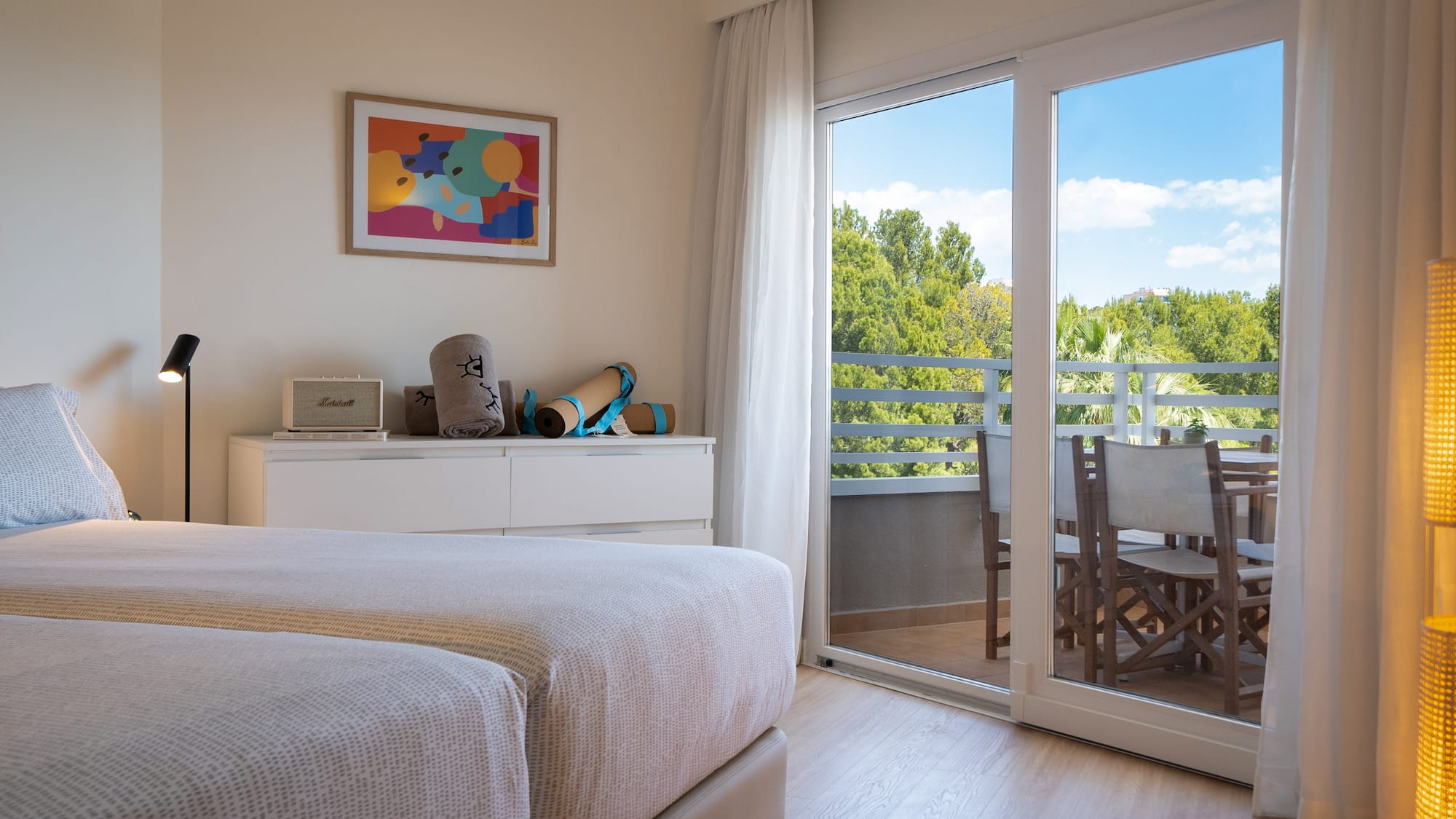 a bedroom with a glass door and a table and chairs
