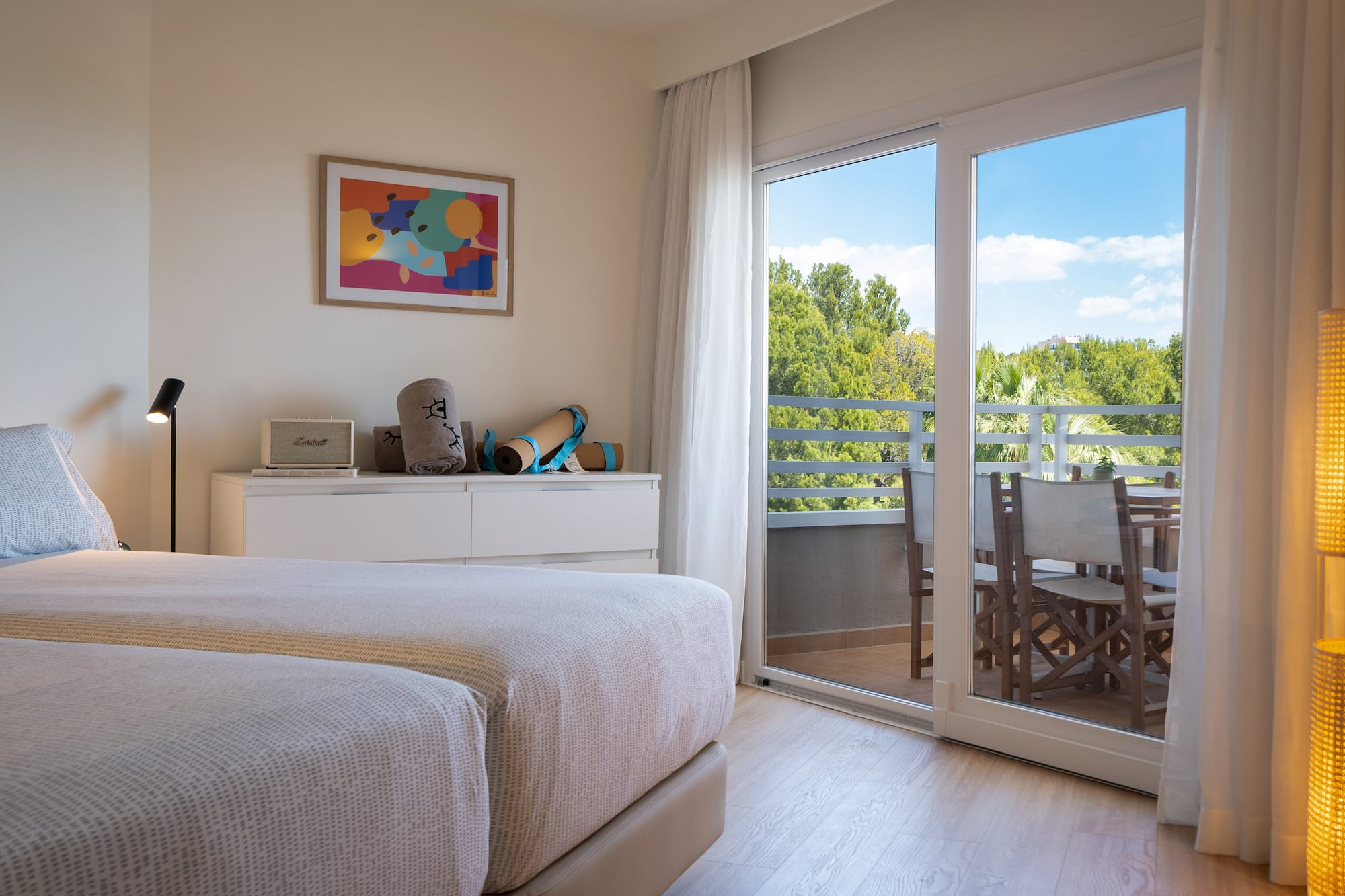 a bedroom with a glass door and a table and chairs