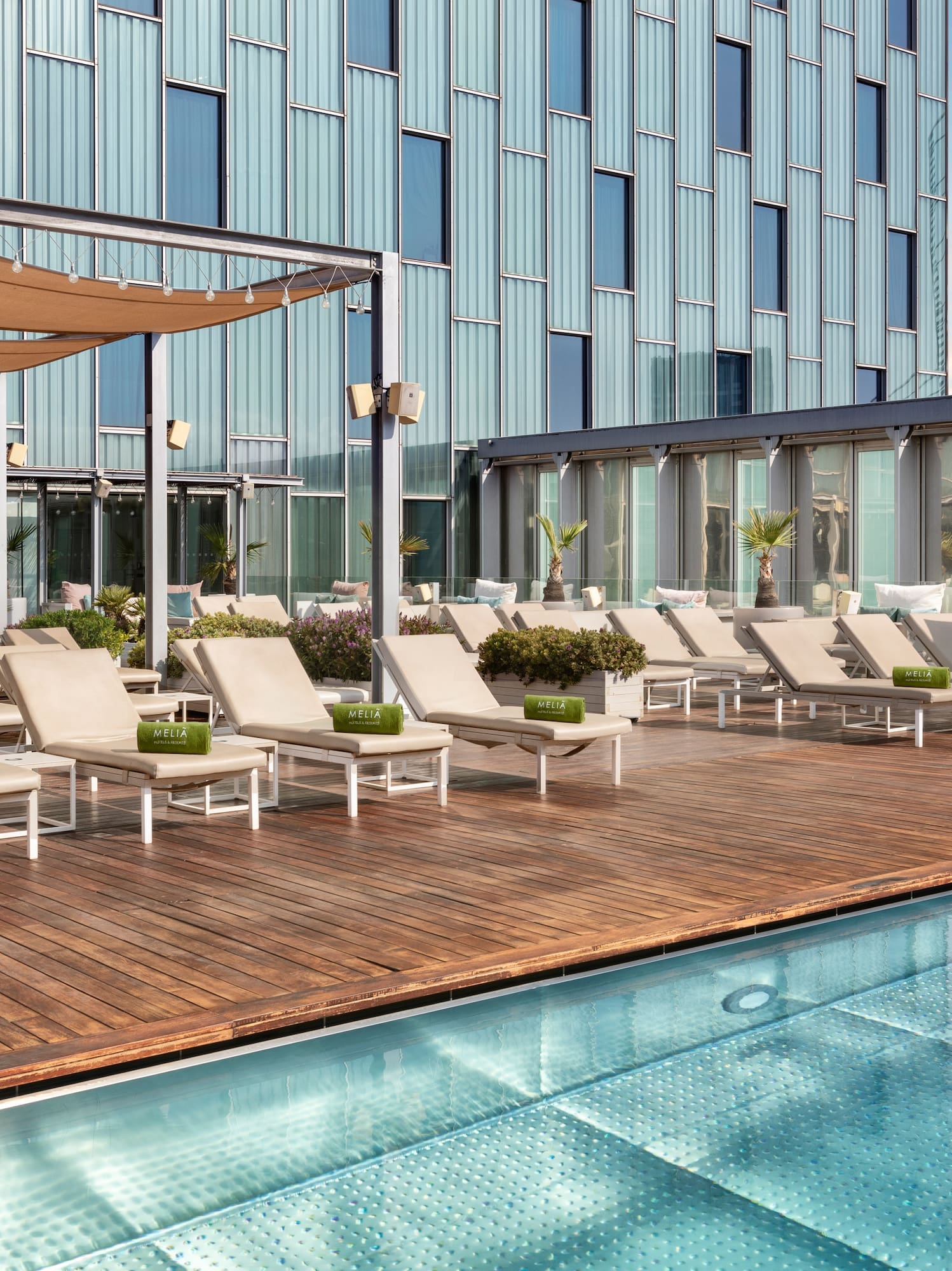 a pool with lounge chairs and a building in the background