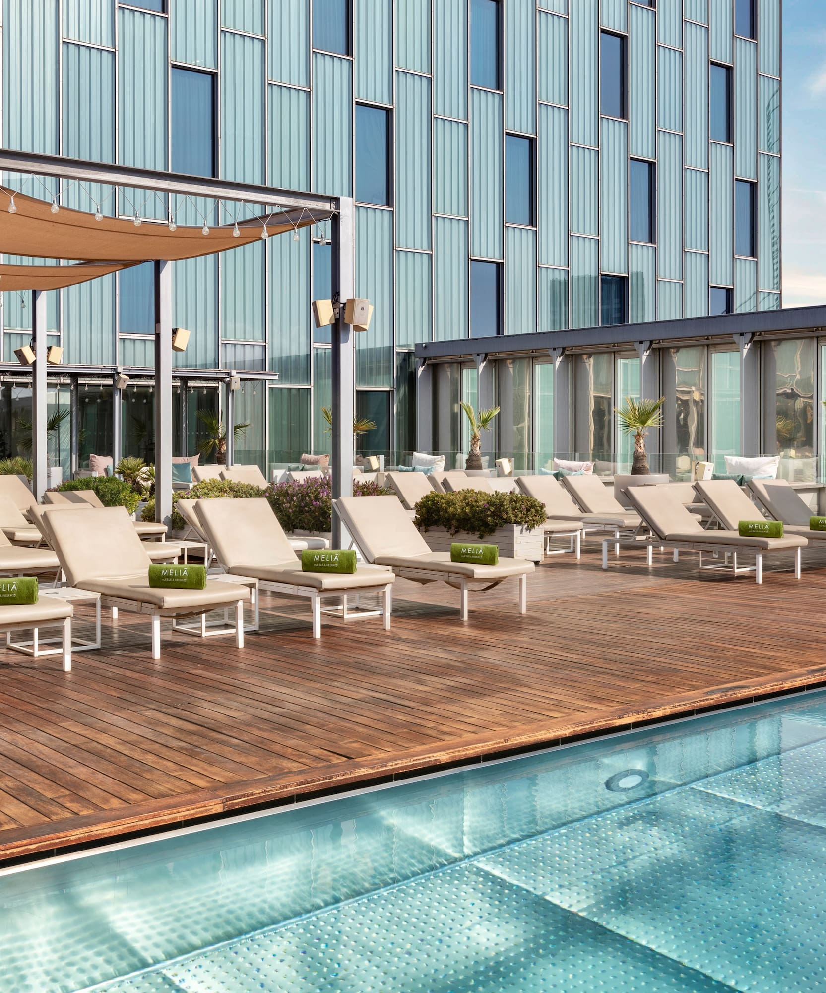 a pool with lounge chairs and a building in the background
