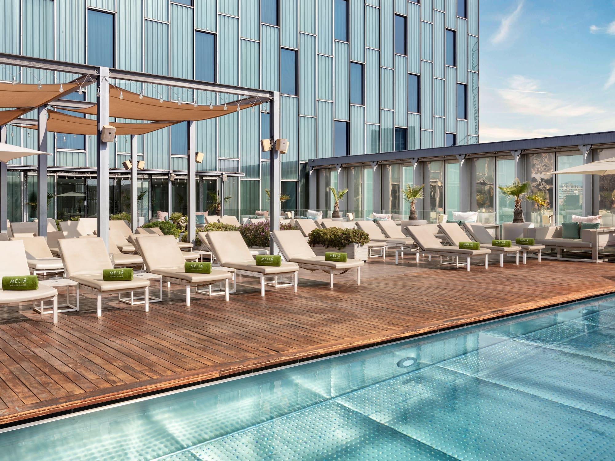a pool with lounge chairs and a building in the background