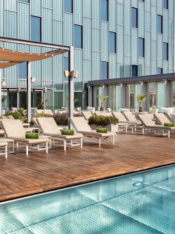 a pool with lounge chairs and a building in the background