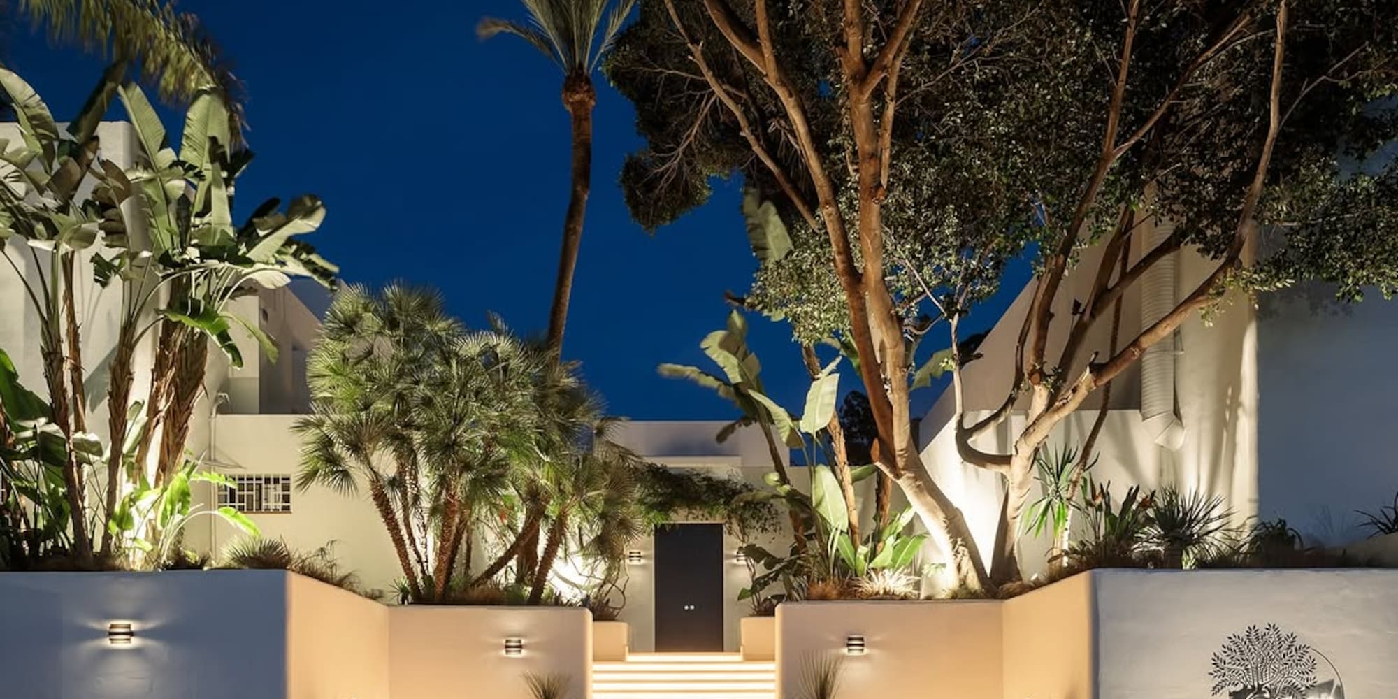 a white building with trees and stairs