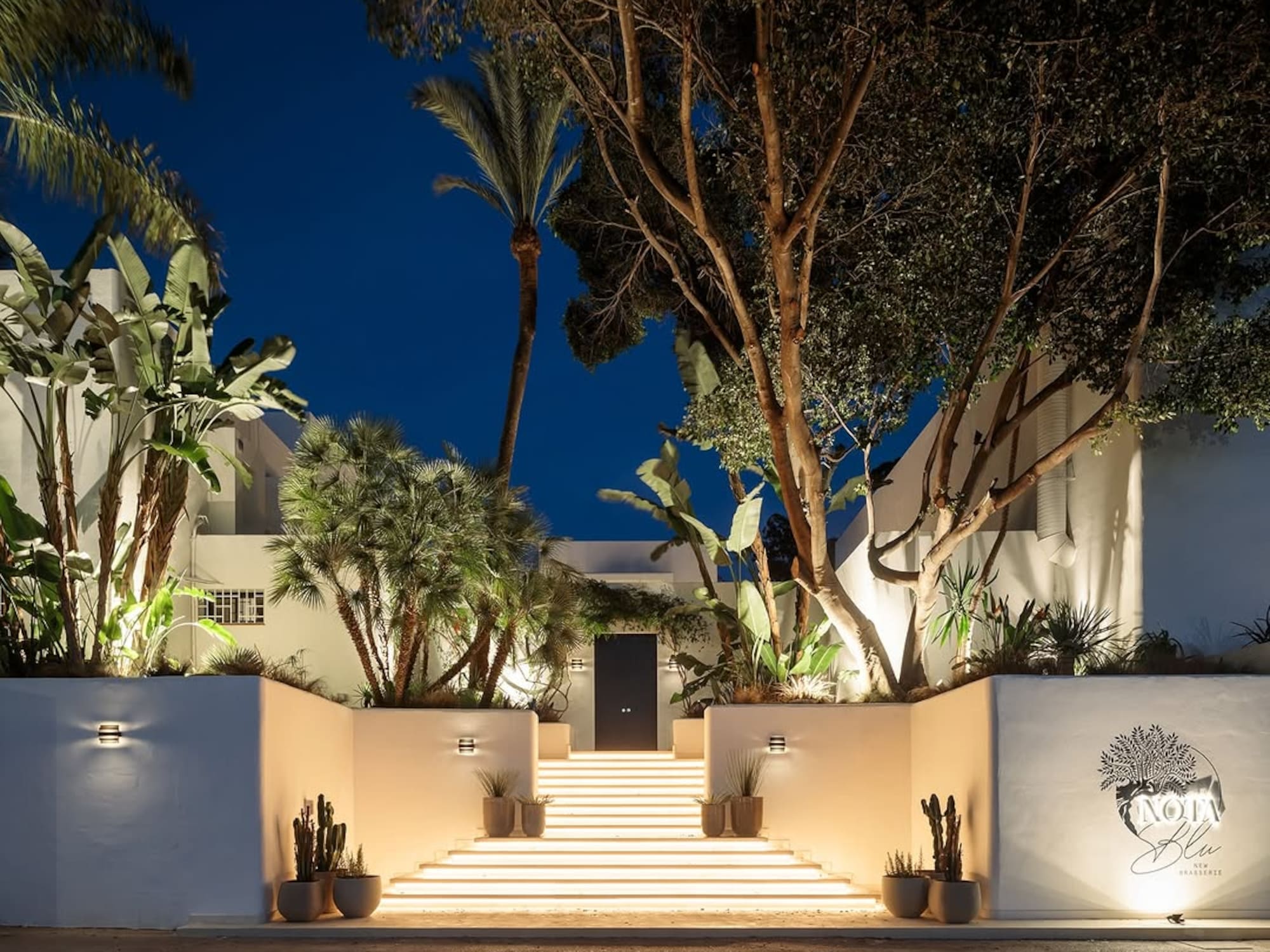 a white building with trees and stairs