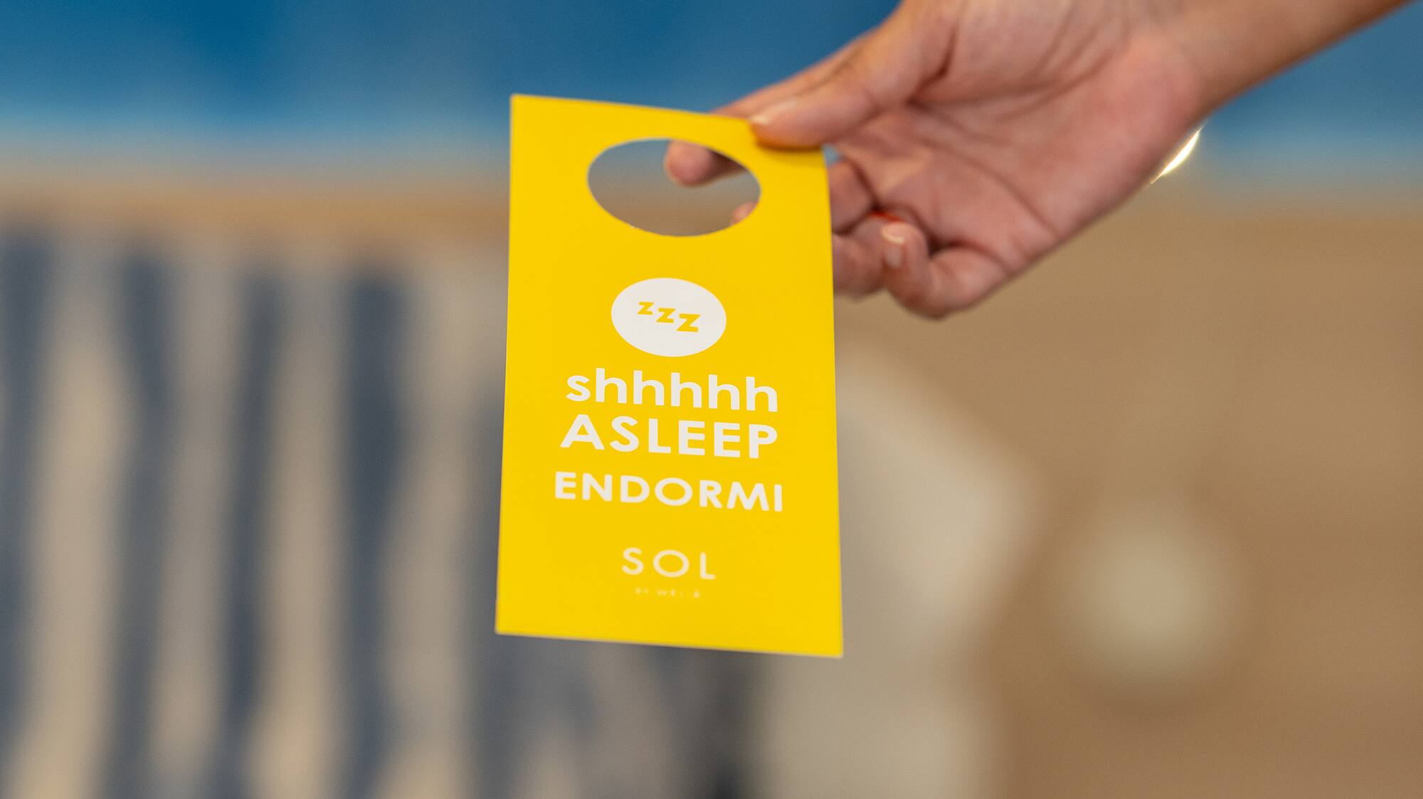 a hand holding a yellow tag