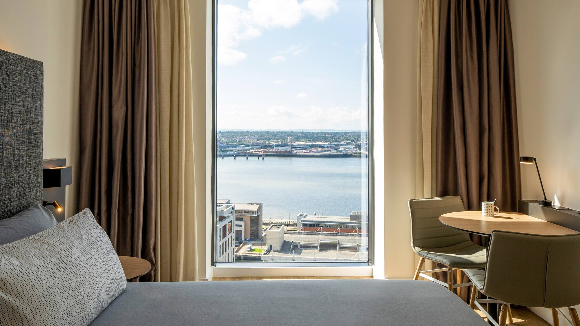 a room with a window and a view of a city and water