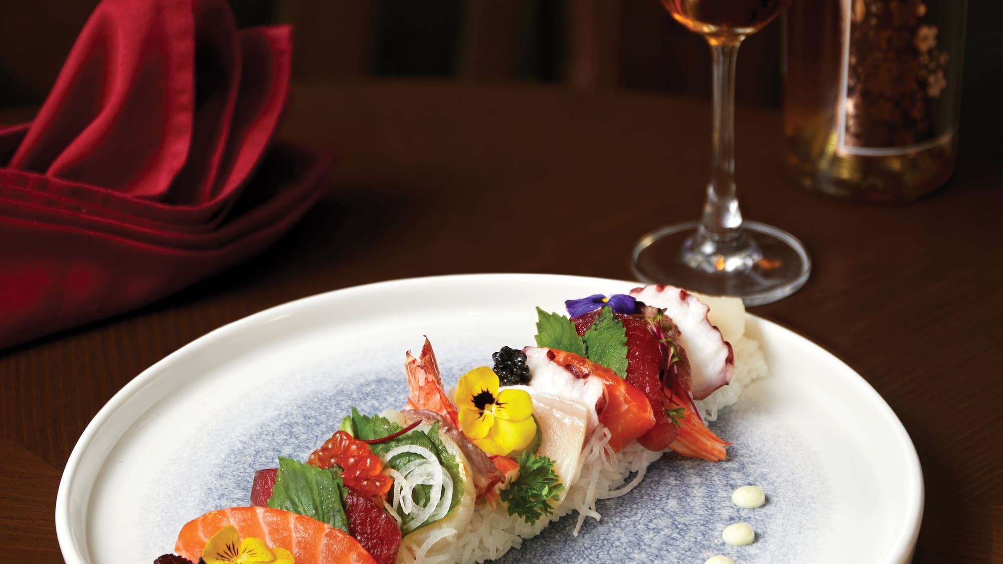 a plate of sushi with a glass of liquid