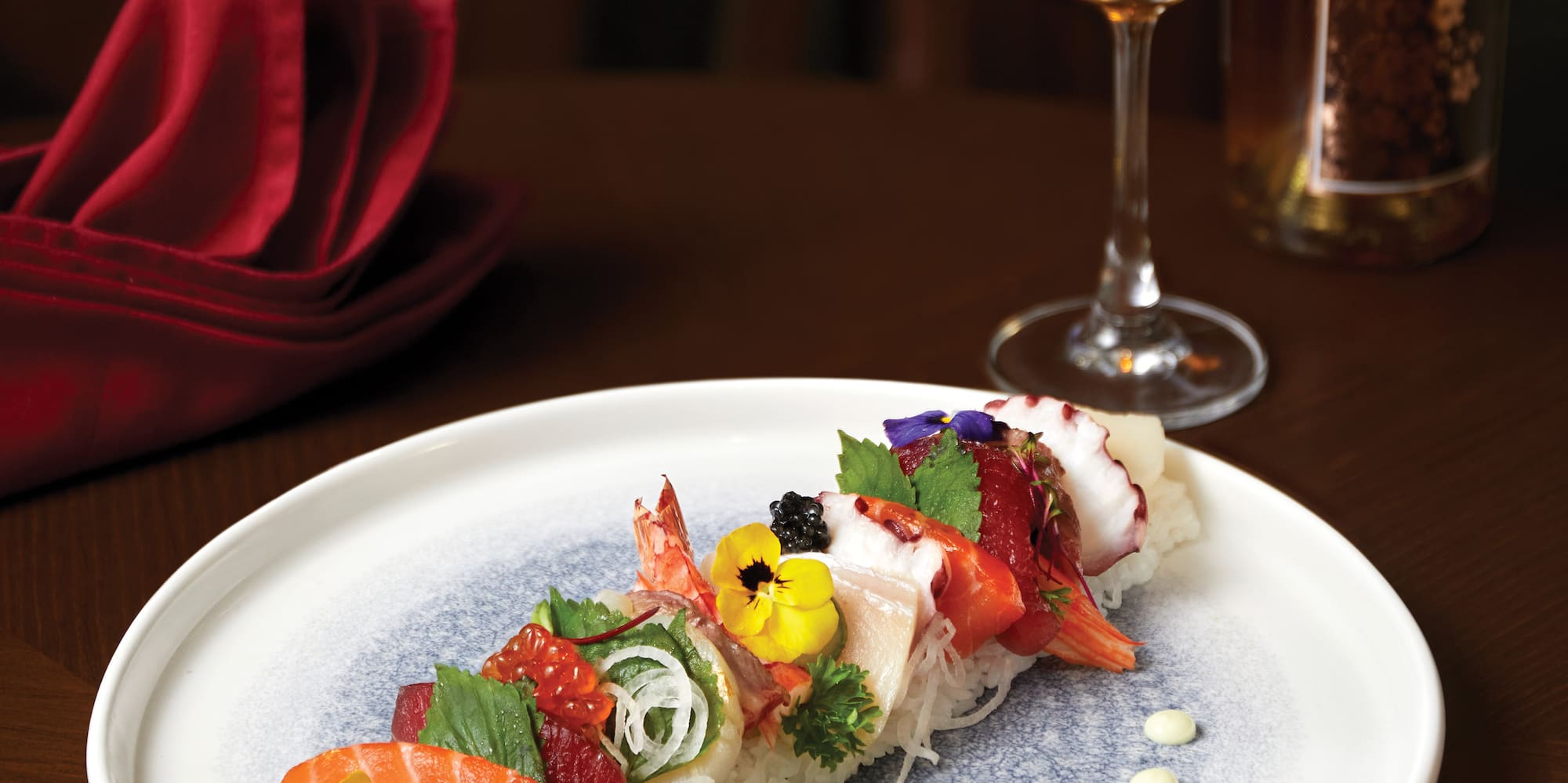 a plate of sushi with a glass of liquid