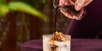 a person pouring a drink into a glass