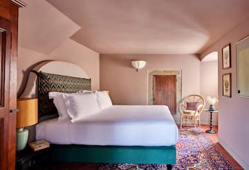 a room with a bed and chairs