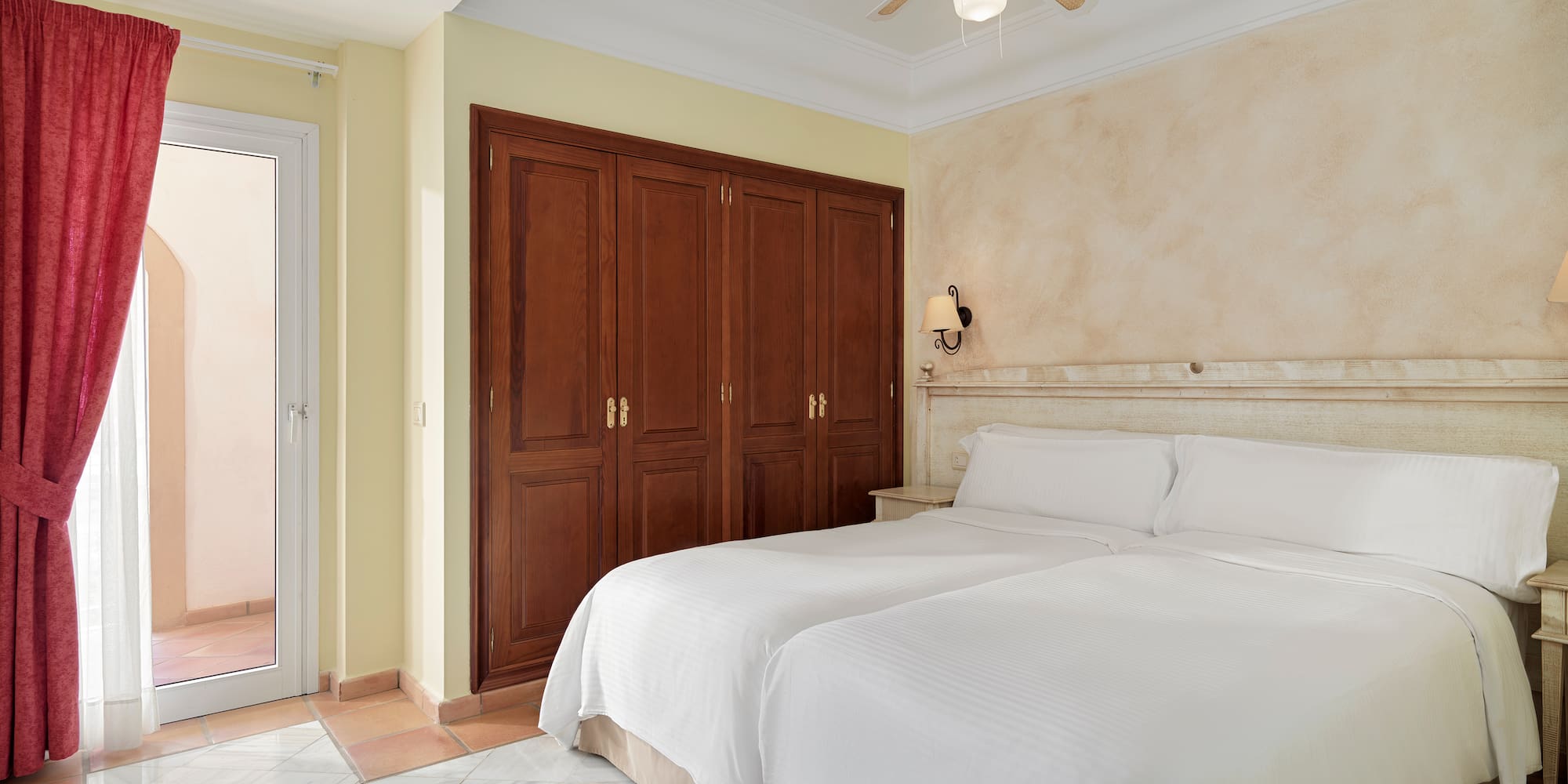 a bedroom with two beds and a ceiling fan