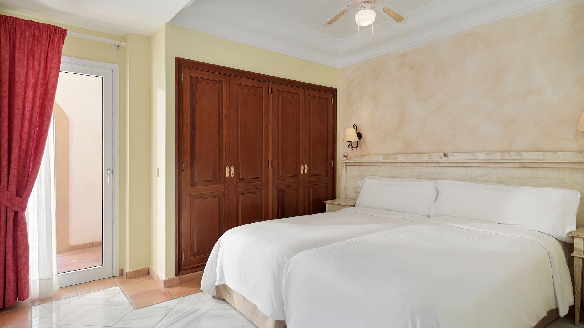 a bedroom with two beds and a ceiling fan