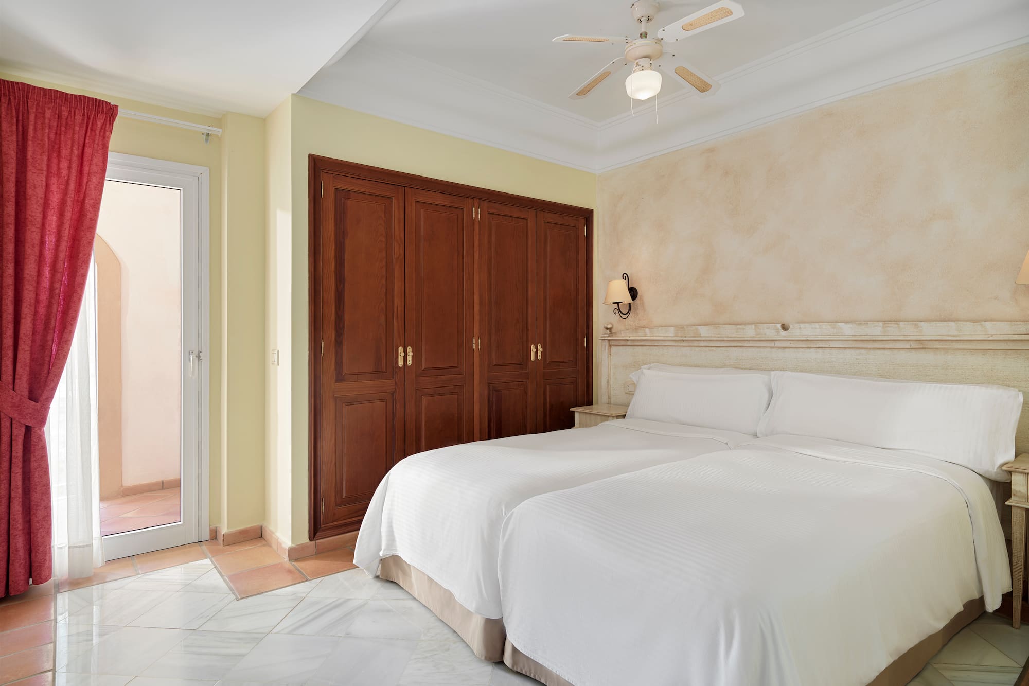 a bedroom with two beds and a ceiling fan