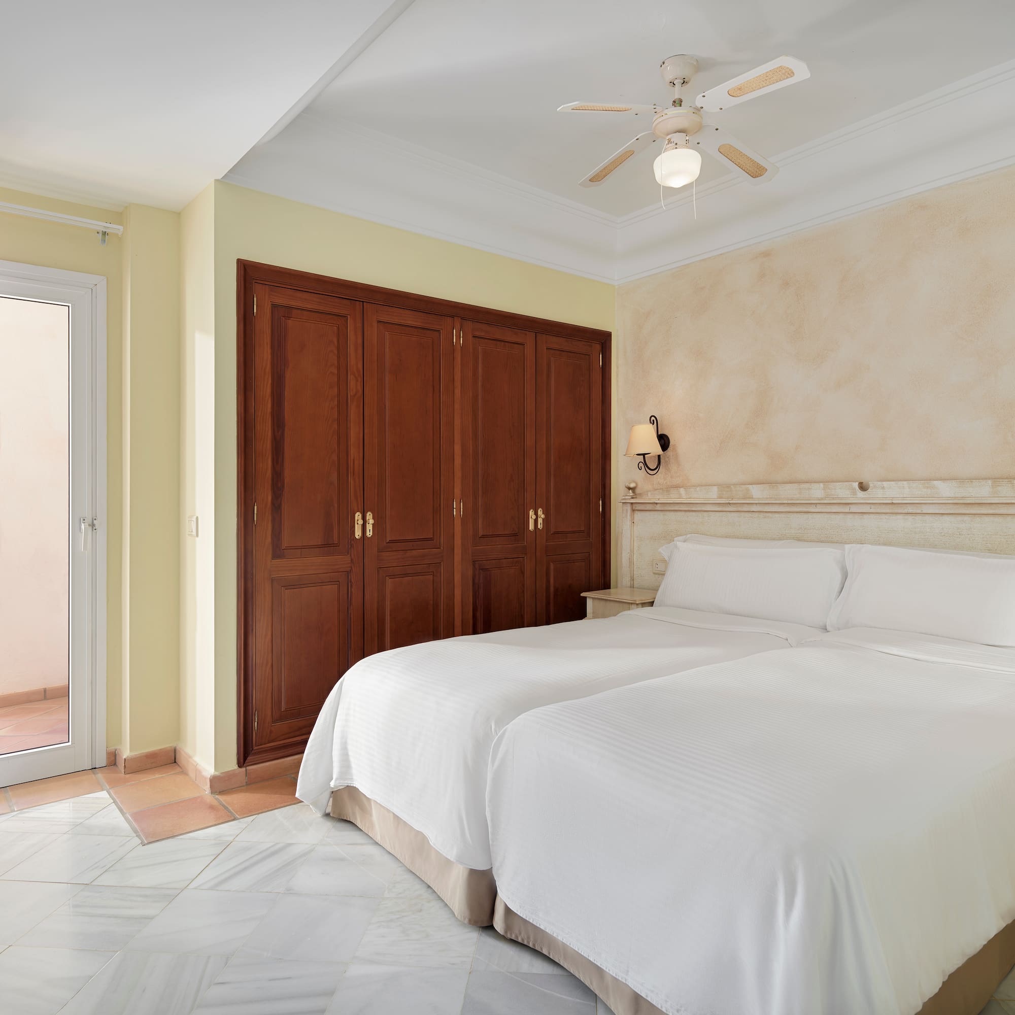 a bedroom with two beds and a ceiling fan