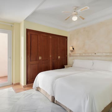 a bedroom with two beds and a ceiling fan