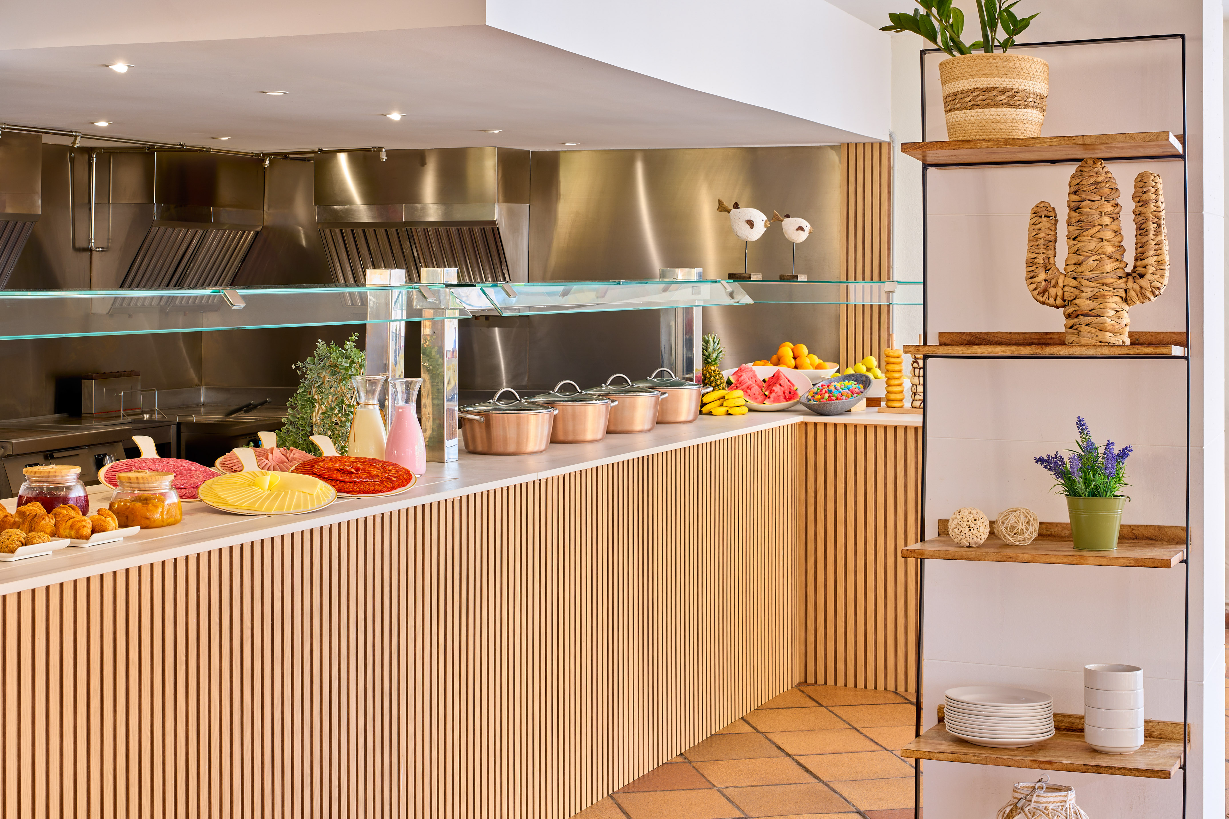 Stylish hotel breakfast buffet featuring fresh fruit, cold cuts, and hot pots.