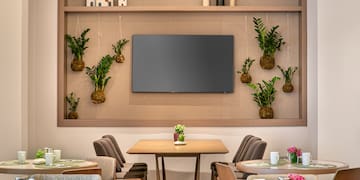 a room with tables and chairs and a television