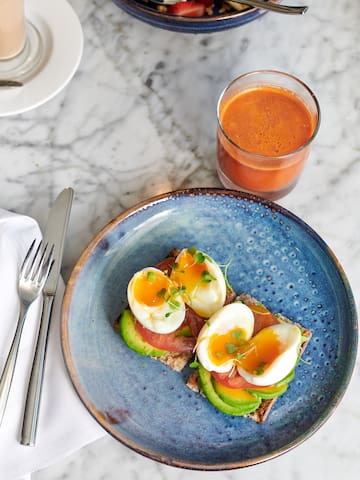a plate of food with a glass of juice and a fork