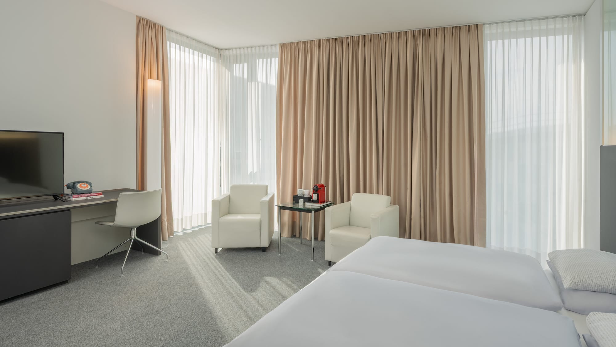 a room with a bed and chairs