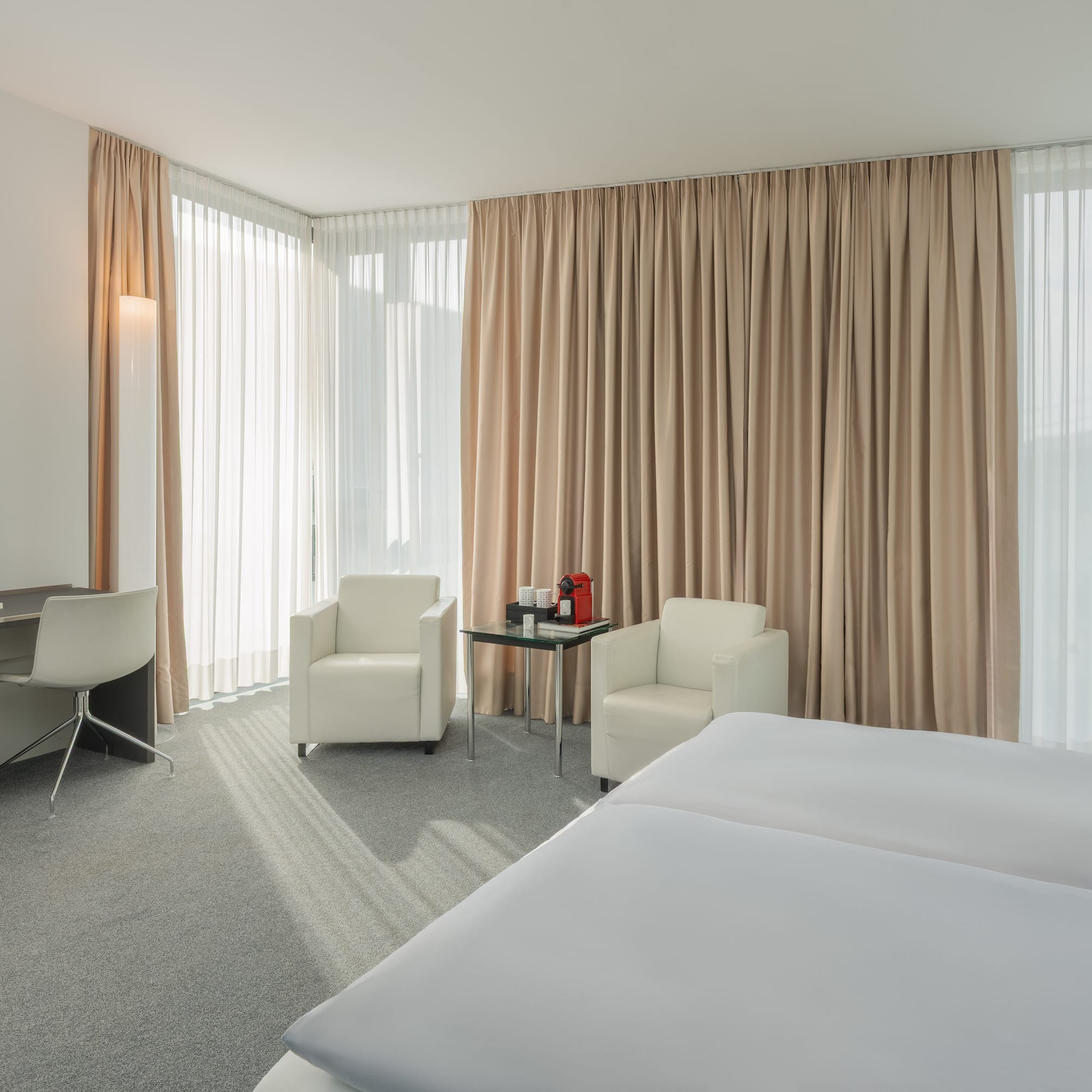 a room with a bed and chairs