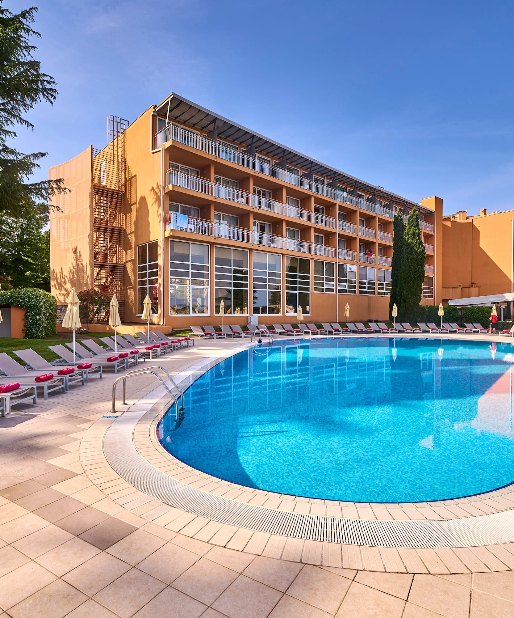 a pool with lounge chairs and a building